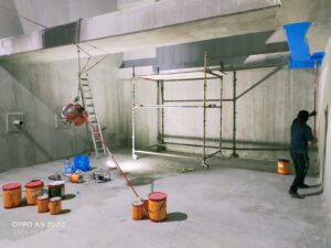 خزان مياه أرضي خرساني كبير يقوم داخله فريق عمل متخصص بعزل الجدران بمادة الإيبوكسي الأزرق مع تنفيذ أعمال تنظيف وصيانة خزانات المياه في مكة